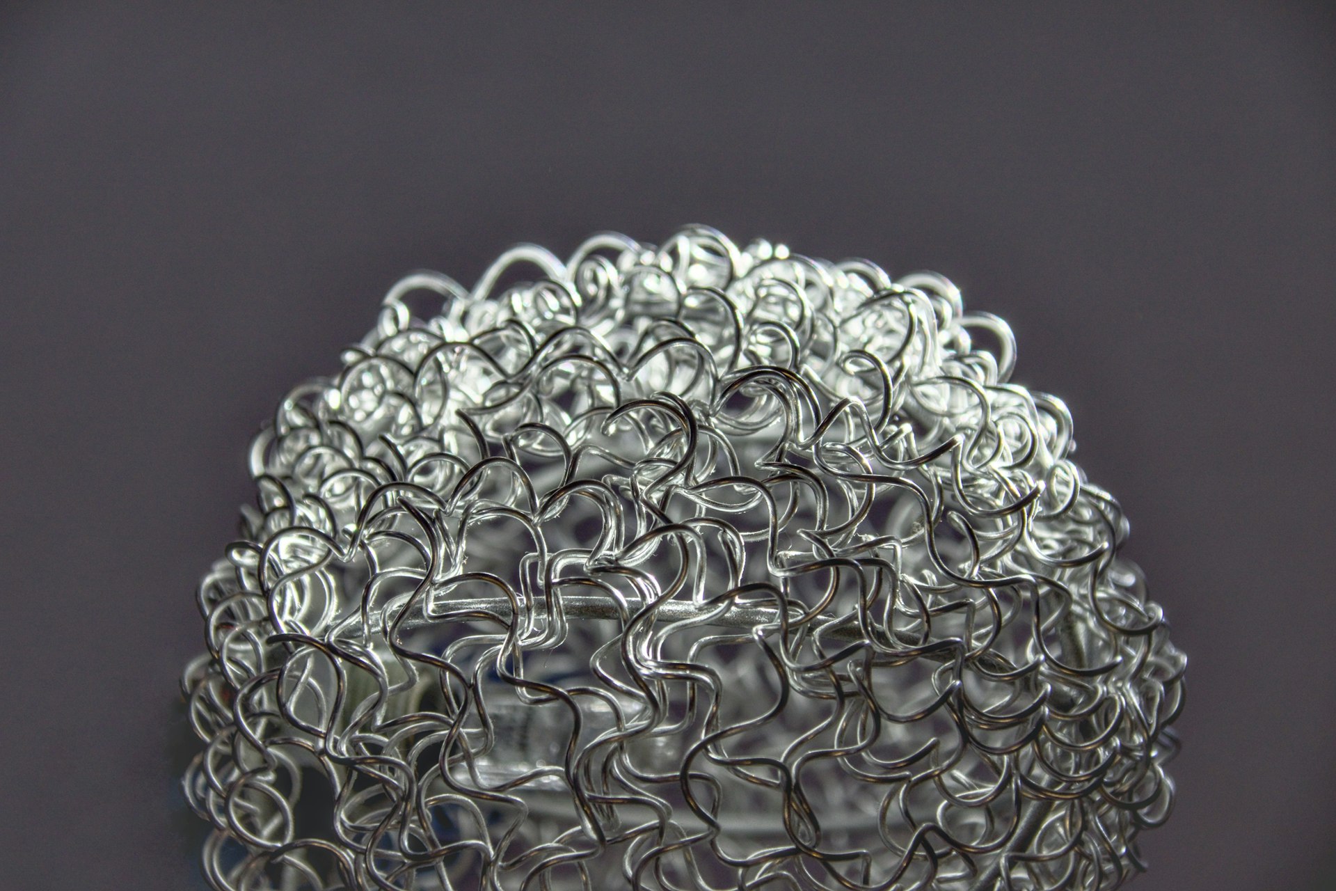 A close-up shows a woven, glass-like structure.